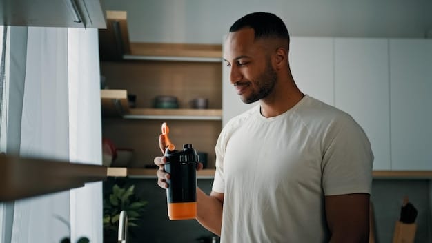 A person preparing a pre-workout drink, mixing powder with water in a shaker bottle, with a focused expression, suggesting preparation for a workout.