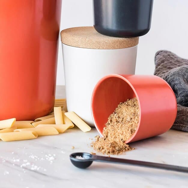A selection of plant-based protein powder containers (e.g., pea protein, rice protein, hemp protein) artfully arranged on a rustic wooden table with fresh, vibrant plant ingredients like peas, rice grains, and hemp seeds scattered around, emphasizing natural and wholesome origins.