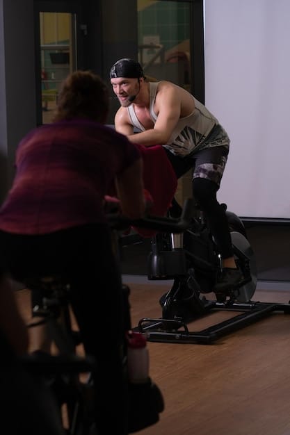 A focused man on an assault bike during a HIIT session, portraying intense effort and determination in a gym setting.