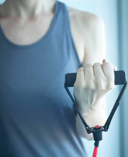 A close-up of a person performing external rotations with a light resistance band, focusing on controlled movement.