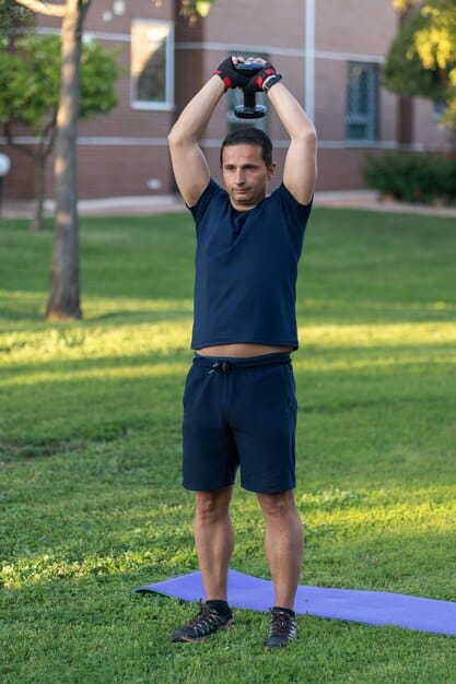 An athlete performing a kettlebell Turkish get-up, demonstrating full body control and overhead stability.