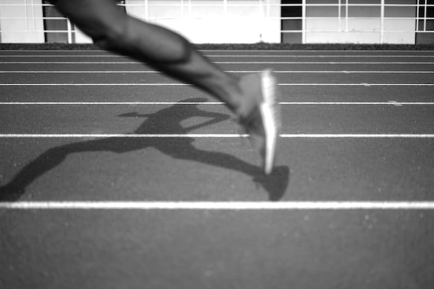 An athlete mid-sprint on an indoor track, showing determination and high effort, with blurred background to emphasize motion.