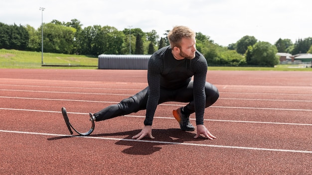 A track athlete in starting blocks, poised to explode into a sprint, demonstrating intense focus and powerful musculature.