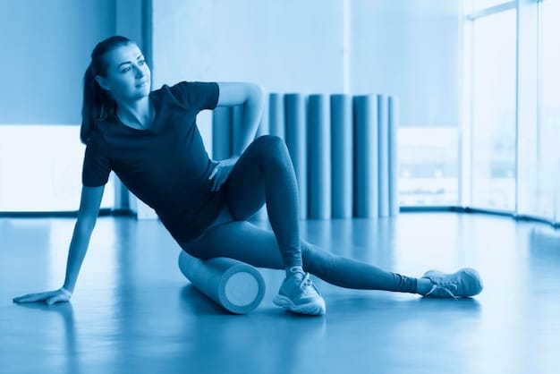 A person using a foam roller on their hamstring, demonstrating effective self-myofascial release for improved leg mobility, against a minimalist gym background.