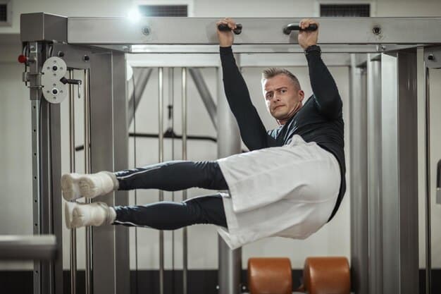 A man performing a hanging leg raise, demonstrating proper form for lower abdominal engagement, with gym equipment in the background.