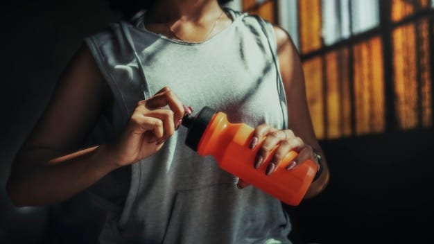 An athlete's hand reaching for a water bottle during a workout, with focus on hydration and sports supplementation bottles in the background.
