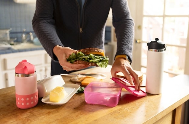 A person in a home kitchen arranging portioned gluten-free meals into containers for weekly meal preparation.