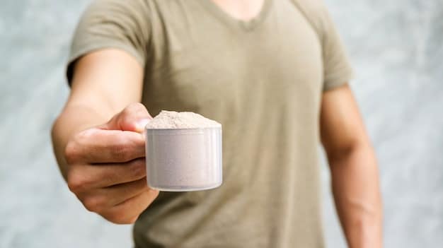 A close-up of a hand scooping creatine powder from a tub into a shaker bottle, with blurred gym equipment in the background. Shows practical application of supplementation.