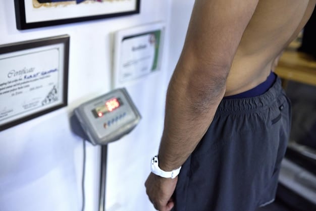 A close-up of a person's hand pressing a digital hand dynamometer, with the screen displaying a strength measurement.